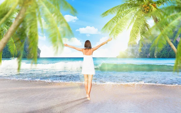 Young girl on the beach with palm trees — Stock Photo, Image