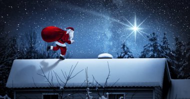 Evin çatısında hediyeleri olan Noel Baba.