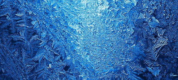 Зимние ледяные синие узоры на стекле — стоковое фото