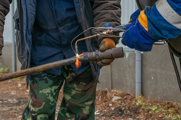 Dwóch Pracowników Łączy Dwie Metalowe Części Pomocą Spawarki Gazowej Zewnątrz — Zdjęcie stockowe