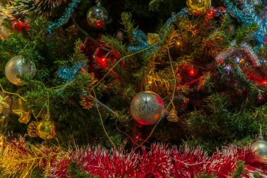 Güzel Noel ağacı süslemeleri: Toplar, süsler, koyu yeşil arka planda parlak bir çelenk. Şenlik havası.