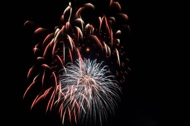 Yeni yıl havai fişeklerinin parlak ışınları Gece gökyüzünün siyah arka planında.
