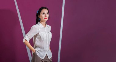 Beyaz gömlekli genç güzel kız pembe duvarın karşısında duruyor. Dikkatlice kameradan uzağa bak..