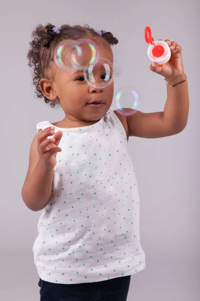 Kleine afrikanisch-amerikanische Mädchen spielt mit Seifenblasen — Stockfoto