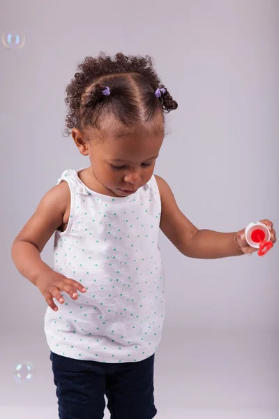 Niña afroamericana jugando con burbujas de jabón — Foto de Stock