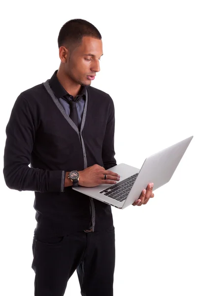Ung amerikansk man använder en bärbar dator — Stockfoto