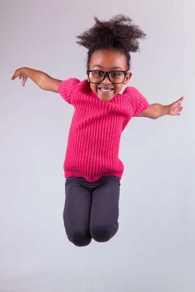 Портрет молодой афроамериканской девушки, прыгающей — стоковое фото