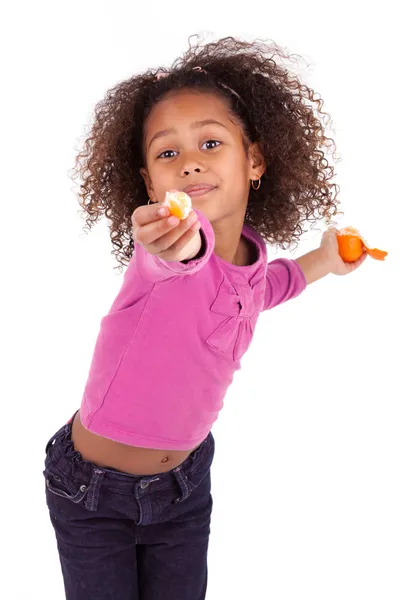 Pouco Africano menina asiática compartilhando uma tangerina — Fotografia de Stock