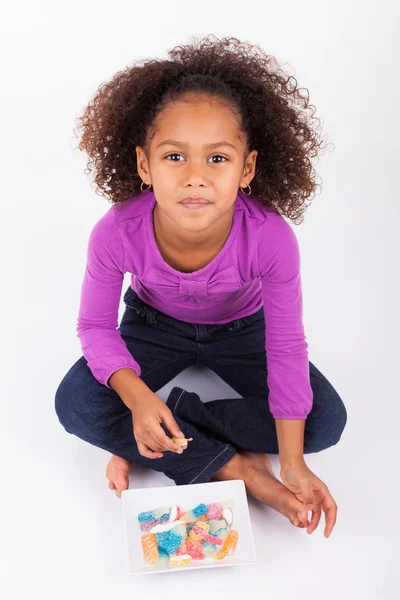 Little African Asian girl eating candy — Stock Photo, Image