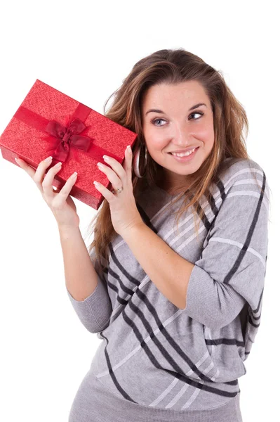Young caucasian woman puting her ear to the present wrapped in r — Stock Photo, Image