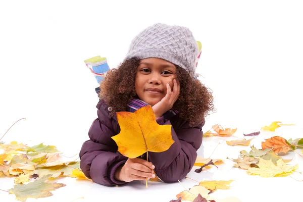 Little african asian girl wearing winter clothes playing with le — Stock Photo, Image