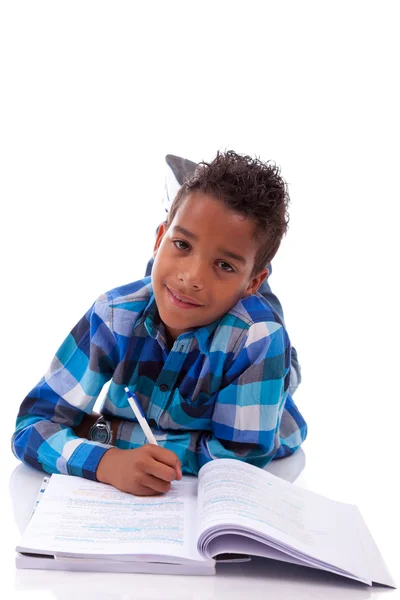 Little african boy lying down on the floor and reading book Royalty Free Stock Photos