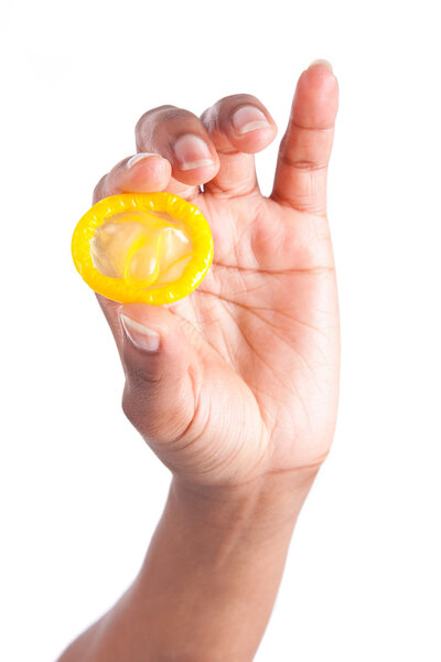 Понятие безопасного секса. Рука с презервативом
