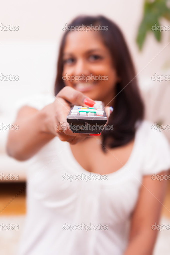 Young indian woman using a tv remote controller