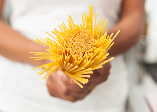 Афроамериканка на кухне держит спагетти — стоковое фото
