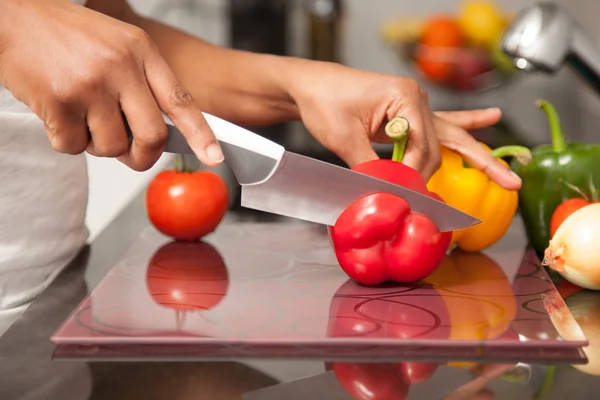 African American womans hand slicing a red pepper — Stock Photo, Image