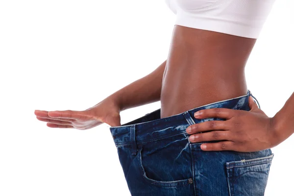 Young african woman in old jeans pant after losing weight — Stock Photo, Image