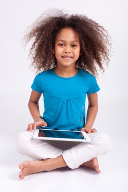 Küçük Afrikalı Asyalı kız tablet PC'yi kullanma