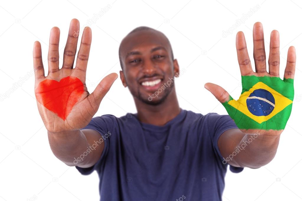 Brazilian man hands with a painted heart and brazilian flag, i