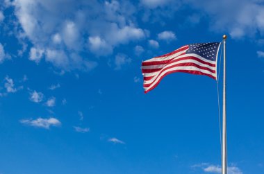 Amerikan bayrağı - yıldız ve çizgiler bulutlu mavi gökyüzünde dalgalanıyor