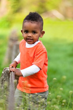 Açık outsi oynarken sevimli genç bir küçük siyah çocuk portresi