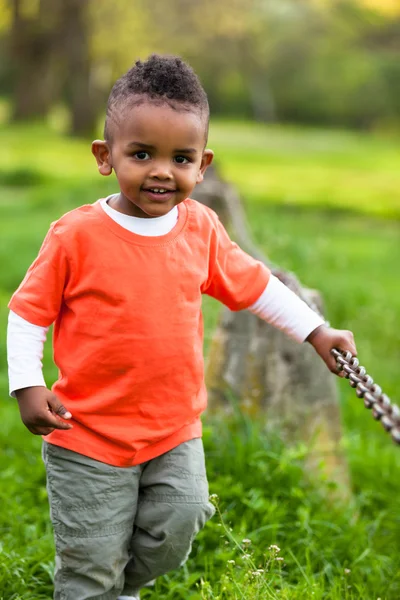 Portrait extérieur d'un mignon jeune garçon noir jouant outsi — Photo