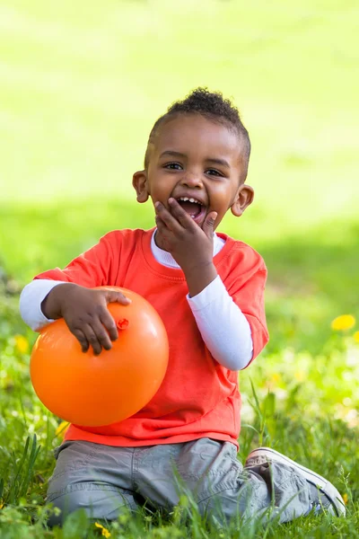 Outdoor portrait of a cute young little black boy playing with — Stock Photo, Image