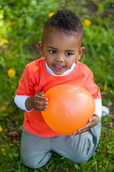 Retrato ao ar livre de um menino pequeno bonito preto brincando com — Fotografia de Stock