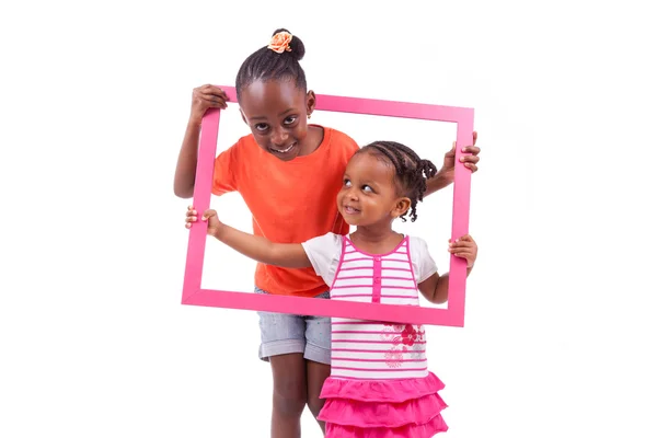 Pequenas meninas americanas africanas segurando uma moldura — Fotografia de Stock