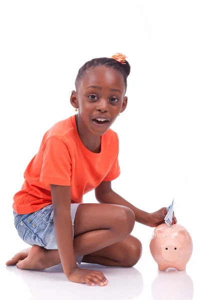 Petite fille noire mignonne insérant un billet d'euro à l'intérieur d'une interdiction de cochon — Photo
