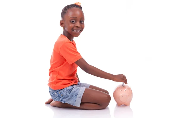 Carino bambina nera inserendo una banconota in euro all'interno di un divieto di maialino — Foto Stock