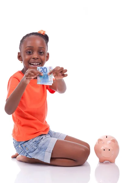 Cute little black girl inserting an euro bill inside a piggy ban — Stock Photo, Image