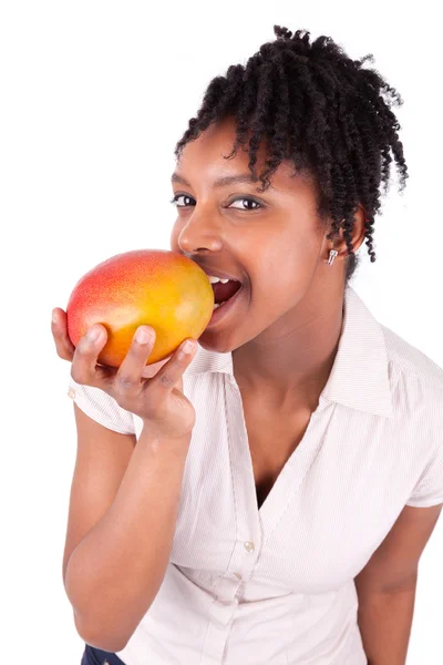Jonge gelukkig zwarte Afrikaanse Amerikaanse vrouw eten vers mango — Stockfoto