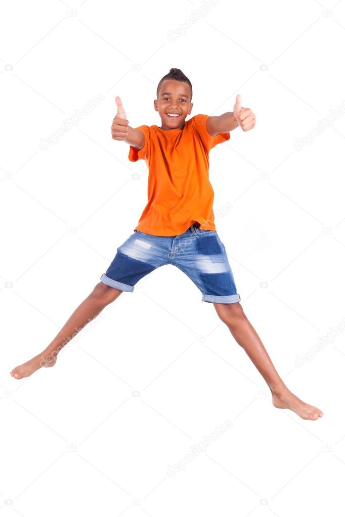 Portrait of a cute teenage black boy jumping over white backgrou