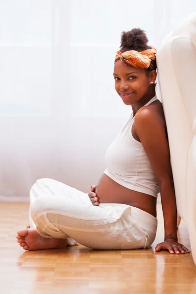 Young pregnant black woman touching her belly - African people Stock Picture