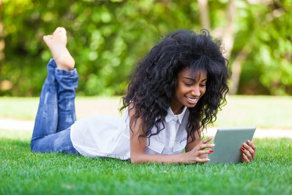 Retrato ao ar livre de uma adolescente negra usando um tablet tátil — Fotografia de Stock
