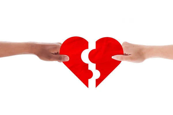 Mixed couple hands holding holding heart shape puzzle — Stock Photo, Image