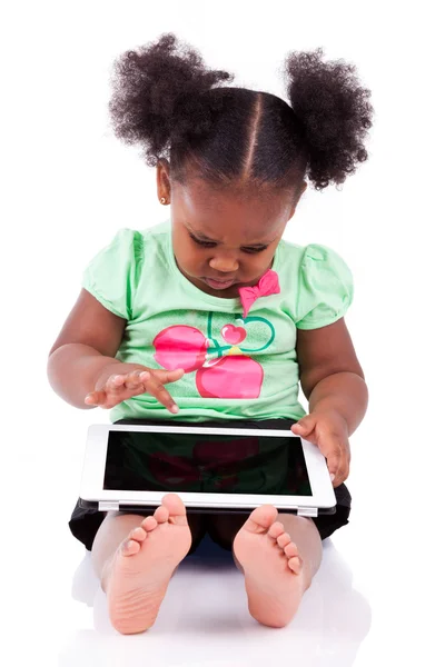 Pequena menina americana africana usando um tablet pc — Fotografia de Stock