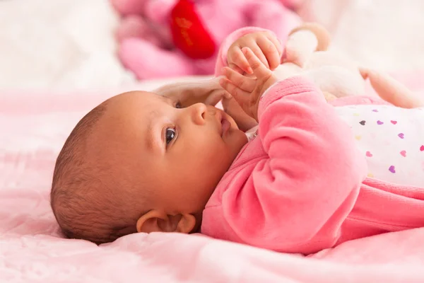 Adorable little african american baby girl playing with a plush — Stock Photo, Image