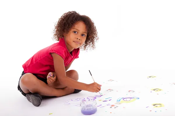 Piccolo africano asiatico ragazza pittura su il pavimento — Foto Stock