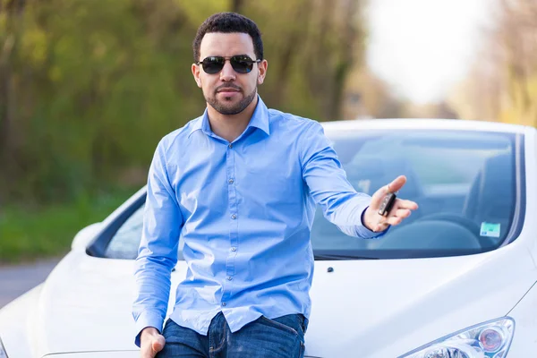 Joven conductor latinoamericano sosteniendo llaves de coche conduciendo su nuevo coche —  Fotos de Stock