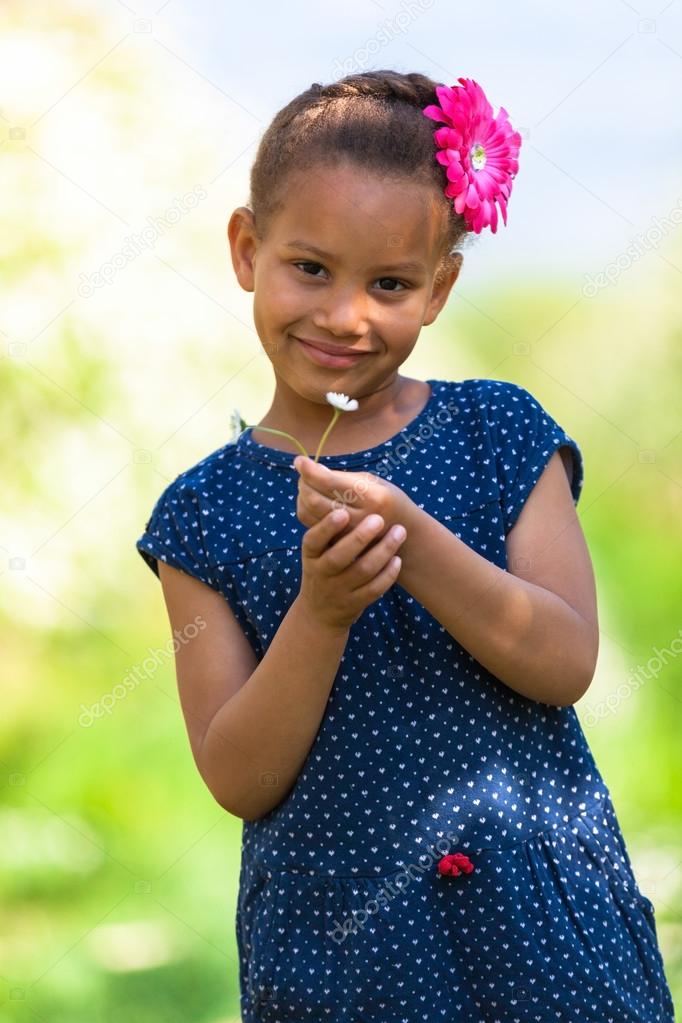 Outdoor portrait of a cute young black girl smiling - African pe