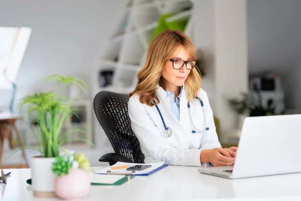 Kvinnlig Läkare Sitter Vid Skrivbordet Och Använder Laptop När Arbetar — Stockfoto