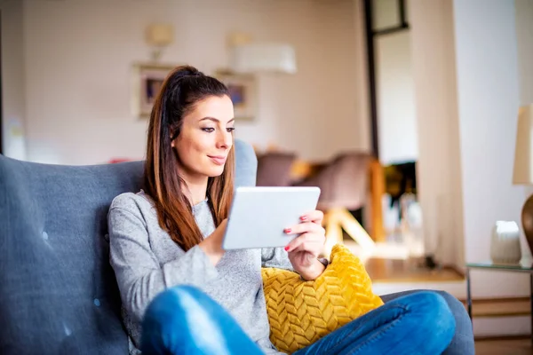 Mujer Sonriente Confiada Usando Tableta Digital Mientras Relaja Sofá Casa — Foto de Stock