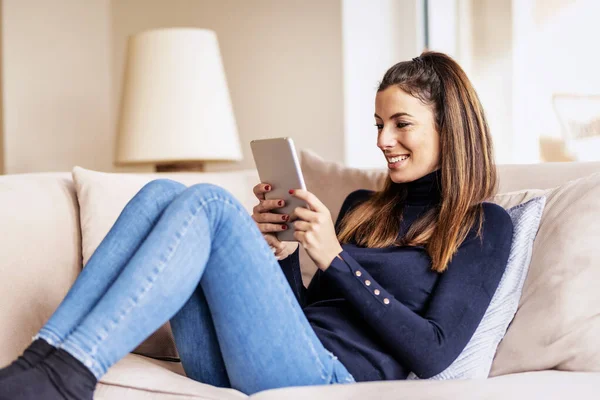 Mujer Sonriente Confiada Usando Tableta Digital Mientras Relaja Sofá Casa — Foto de Stock