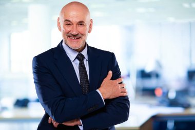 İdari işadamı ofiste kolları bağlı dururken takım elbise ve kravat takıyor.. 