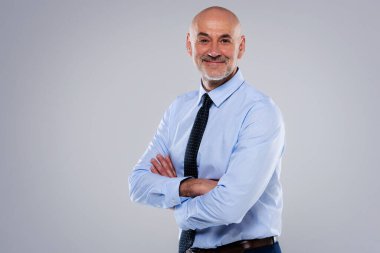 Açık gri arka planda dikilirken orta yaşlı bir iş adamının gömlek ve kravat taktığı görüntüler. Boşluğu kopyala. 