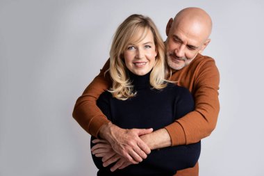 Mutlu orta yaşlı bir çiftin fotokopi odasıyla izole edilmiş arka planda yan yana durduğu bir fotoğraf. Güzel, sarı saçlı bir kadını embriyolaştırırken mutlu ol.. 