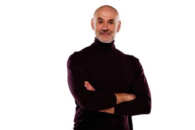 İzole edilmiş beyaz arka planda dikilirken gündelik kıyafetler giyen orta yaşlı yakışıklı bir adamın stüdyo portresi..