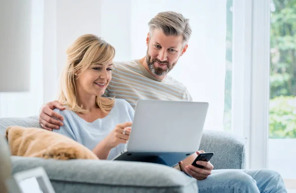 Shot Lovely Couple Relaxing Couch Home Using Laptop Mobile Phone — Foto de Stock